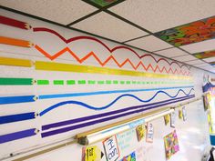 a classroom wall decorated with colorful art on it