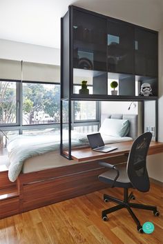 a bed sitting under a window next to a desk