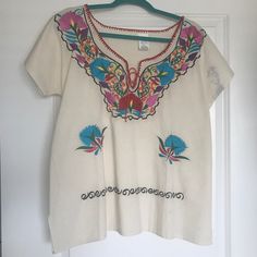 Never Worn- Authentic Embroidered Mexican Blouse. Made And Purchased In Mexico. Multicolored Embroidery Along The Front Neckline And At The Bottom. There Is A Dye Stain On The Left Sleeve That Came With The Blouse When I Got It. White Crew Neck Blouse With Embroidered Hem, Traditional Crew Neck Top With Floral Embroidery, White Blouse With Embroidered Hem And Crew Neck, White Top With Embroidered Border For Spring, Traditional White Top With Floral Embroidery, Traditional White Tops With Floral Embroidery, White Embroidered Top With Hem Detail For Festivals, White Tops With Embroidered Border For Spring, Traditional Crew Neck Blouse With Multicolor Embroidery