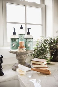 two bottles of soap sitting on top of a counter next to some scrubs and toothbrushes