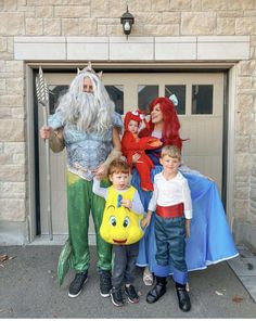 a group of people standing next to each other in front of a garage door wearing costumes