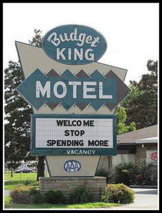 a motel sign with the words budger king on it's side in front of a building