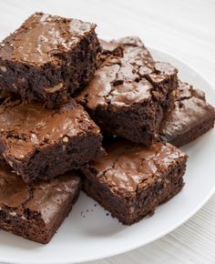 a white plate topped with brownies covered in frosting