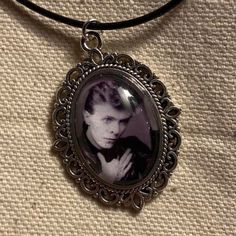 a black and white photo of a man in a frame on a leather cord necklace