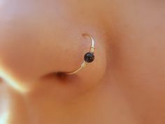 a close up view of the side of a woman's breast with a nose ring