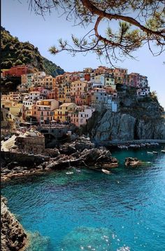 the village is perched on top of a cliff above the water's blue waters