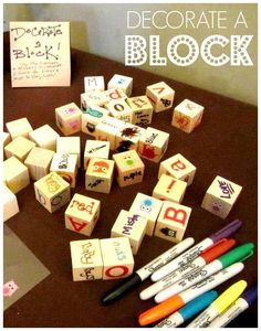 a table with markers and dices on it, next to a note board that says decorate a block