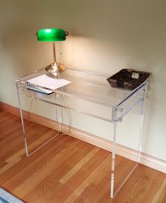 a clear desk with a green lamp on top