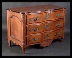 an old wooden dresser with ornate carvings on the top and bottom drawers, is shown