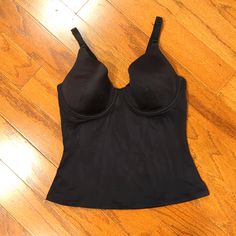 Black In Color. Padded Bra. Convenient Adjustable Strap. Elastic Back For Easy Slip In And Off; No Need To Fumble With Hooks! Light And Smooth To The Touch! Fitted Black Bra-friendly Tank Top, Black Top With Adjustable Straps And Underbust Shape, Black Tops With Adjustable Straps And Underbust Shape, Black Fitted Underwire Shapewear, Black Shapewear Bra With Medium Bust Support, Black Camisole With Adjustable Straps, Black Full Coverage Shapewear With Adjustable Straps, Black Shaping Shapewear With Adjustable Straps, Black Stretch Camisole With Removable Bra Pads