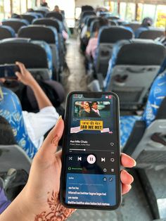 someone is holding up their cell phone to take a photo on the bus with people in seats behind them