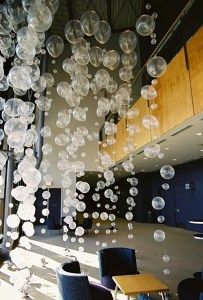 a bunch of bubbles floating in the air over a room filled with tables and chairs