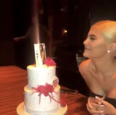 a woman sitting in front of a white cake