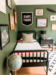 a bedroom with green walls and pictures on the wall