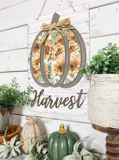 a wooden sign that says harvest with sunflowers and pumpkins on the front