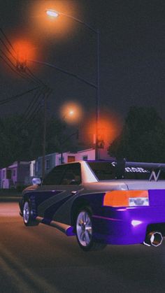 an image of a car that is purple and orange in the dark street at night