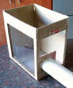 an open cardboard box sitting on top of a counter next to a roll of toilet paper