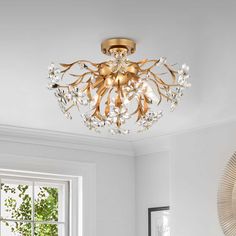 a chandelier hanging from the ceiling in a room with white walls and windows