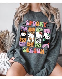 Get ready to embrace the spooky season with our Hello Kitty Spooktacular Sweater! Featuring your favorite feline in a Halloween-themed design, this cozy sweater combines cute and creepy with Hello Kitty surrounded by ghosts, pumpkins, and bats. Perfect for fans who love a dash of spooky with their style, this sweater will keep you warm and stylish all autumn long. Made from high-quality materials, it's as comfortable as it is charming. Whether you're trick-or-treating or just enjoying a chilly f Fall Kawaii Style Sweatshirt With Cartoon Print, Kawaii Cartoon Print Sweatshirt For Fall, Kawaii Letter Print Sweatshirt For Fall, Playful Cartoon Print Sweater For Fall, Black Cartoon Print Sweater For Fall, Black Sweater With Cartoon Print For Fall, Fall Hello Kitty Long Sleeve Top, Fall Kawaii Sweatshirt With Graphic Print, Fall Kawaii Graphic Print Sweatshirt