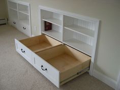 an open drawer in the middle of a room with bookshelves on either side