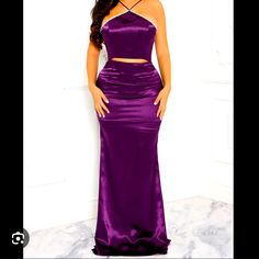 a woman in a purple dress posing for the camera