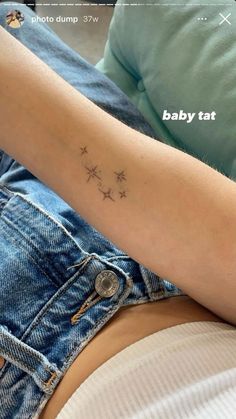 a woman's arm with stars on it and the word baby tat written in cursive font