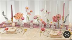 the table is set with pink flowers and candles