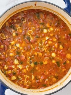 a blue pot filled with pasta and vegetables