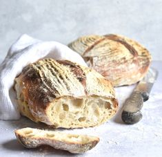 a loaf of bread sitting on top of a table next to a piece of bread