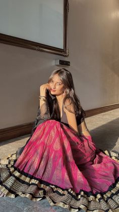 a woman sitting on the floor in a pink dress