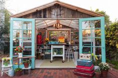 an outdoor garden shed with lots of plants and flowers in the window panes,