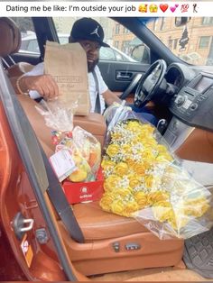 a man sitting in the back seat of a car with flowers and bags on it