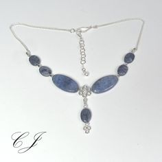 "Dumortierite is a rare blue gemstone that usually forms as inclusions in quartz. This adjustable necklace is handmade using Flower and Sunset Dumortierite beads. This classic necklace is completely handmade by Cohee Jewelry in USA.  The elegant style would be a great jewelry accessory or evening or formal wear. Matching earrings are available for both pierced and non-pierced ears.  Clasp: Handmade Sterling Silver Hook Extender: Handmade 2\" Sterling Silver Swarovski Crystal Pearl accent beads. Necklace Length: 16.25\" to 18.25\" Necklace Style: Choker - Princess Pendant drop length: 1.5\" (38 mm) Chain: 2 mm Sterling Silver Drawn Cable All metal components are 925 Sterling Silver Dimensions are approximate. Matching earrings for pierced or non-pierced ears: https://www.etsy.com/listing/95 Princess Pendant, Button Pearl Earrings, Beaded Necklace Blue, Blue Gemstone Necklace, Aquamarine Pendant, Big Pearl, Jasper Earrings, Necklace Flower, Classic Necklace