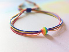 Minimalistic bracelet with rainbow bead and 6 colorful strings. Perfect for the parade, festival or to wear daily (me!) :) Fits wrists for up to 24cm, if you require other size please message me :) Thanks! Rainbow Friendship Bracelets With Sliding Knot, Rainbow Sliding Knot Bracelets For Friendship, Adjustable Rainbow Friendship Bracelets With Sliding Knot, Rainbow Sliding Knot Bracelet For Friendship, Rainbow Sliding Knot Friendship Bracelet, Adjustable Multicolor Bracelets For Pride, Rainbow Adjustable Cord Friendship Bracelet As Gift, Rainbow Sliding Knot Bracelet As Gift, Adjustable Rainbow Braided Bracelets For Festivals