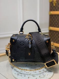 a black louis vuitton bag sitting on top of a table