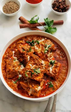 a white bowl filled with meat and sauce