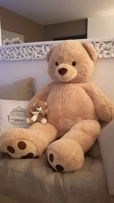 a large teddy bear sitting on top of a bed