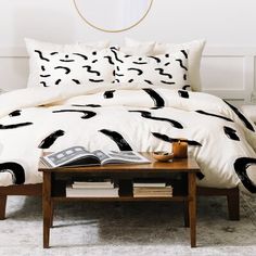 a bed with black and white designs on the comforter, pillows and pillow cases