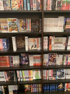 a book shelf filled with lots of books and video game controllers next to each other