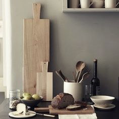 a table topped with plates and bowls filled with food on top of a wooden cutting board