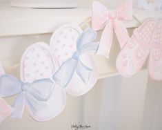 there are baby shoes hanging on the clothes line with ribbons attached to it's sides