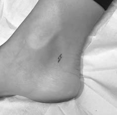 a person's foot with a small tattoo on the side of their left leg