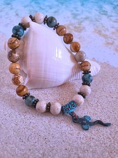 Get those sandy vibes flowing with our Beachy Bracelets, featuring natural stones, patina green accents, pearls, and cute ocean-inspired charms. Our Mykonos Collection would not be complete without some versatile, easy-to-use stretch bracelets. Wear one alone or stack a few for a bold BoHo look. Each bracelet features antiqued patina charms and spacers made in Greece, where the art of metal finishing was popular already thousands of years ago. Pearls, stingrays, shells, and other fun shapes ador Bohemian Hand-strung Stretch Bracelet For Vacation, Bohemian Gemstone Beads Bracelets For Beach, Bohemian Gemstone Beads Bracelet For Beach, Bohemian Stretch Bracelet For Vacation, Earthy Natural Stone Beaded Bracelets For Beach, Spiritual Gemstone Beaded Bracelets For The Beach, Beach Bracelets With Natural Stones And Round Beads, Bohemian Stretch Bracelet With Gemstone Beads For Beach, Casual Beach Beaded Bracelets With Natural Stones