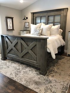 a bedroom with a large bed and wooden headboard on top of a carpeted floor