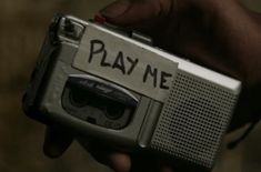 a person holding an old fashioned radio with play me written on the front and side