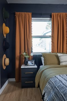 a bedroom with blue walls and orange drapes