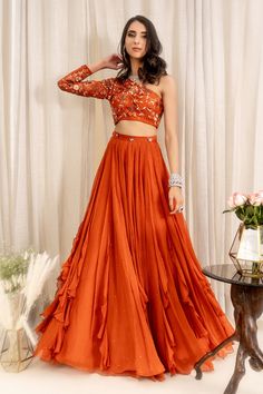 Rust orange one shoulder blouse with all-over floral embroidery. Paired with 
Component: 2
Embroidered
Neckline: One Shoulder
Sleeve Length: Asymmetric
Fabric: Tulle Net, Georgette, Shantoon
Color: Orange
Frill panel lehenga
Blouse: Concealed zip at the side - Aza Fashions Lehenga With Net Frill, Orange Sangeet Outfit, One Shoulder Lengha Blouse, One Shoulder Indian Blouse, Grahshanti Outfit, Orange Theme Outfit, Burnt Orange Lengha, One Shoulder Indian Outfits, Frill Lehenga Designs