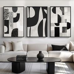 three black and white paintings hanging on the wall above a couch in a living room