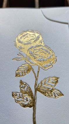 a white card with gold foiled roses on it