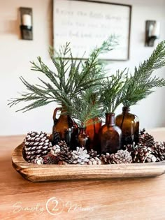 a tray with pine cones and bottles filled with evergreen branches